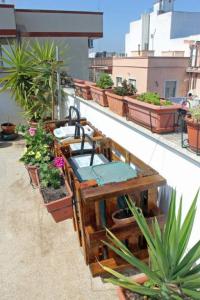 Eine rollende Mülleimerumzäunung aus Paletten mit Mülleimern und angehängten Blumenkästen für Garten und Terrasse