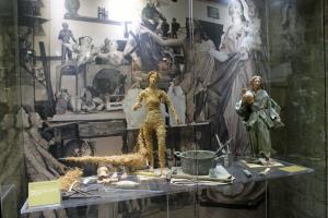 Ein Arbeitstisch in einer Pappmache-Werkstatt mit Geröten und Figuren.