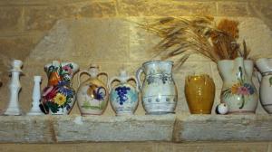 Auf einem Mainsims der Masseria Tenuta Patronio Pertniola sind dekorativ Keramikgefäße aus Grottaglie aufgereiht.