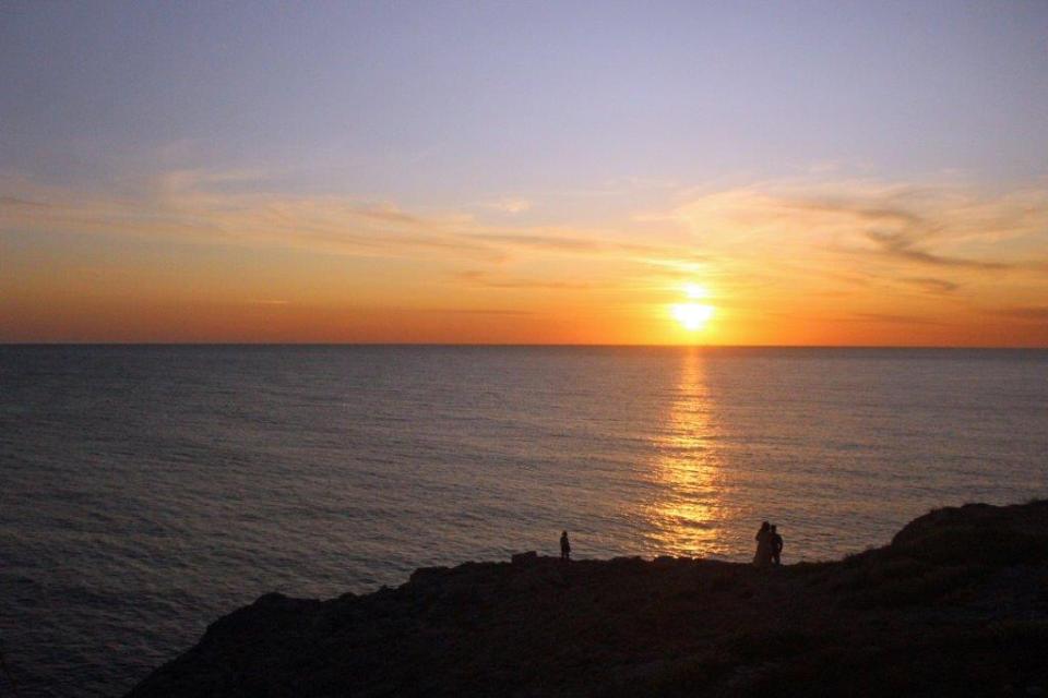 Über dem Meer geht die Sonne in einem orangenen Farbenspektakel bei Santa Maria di Leuca in Apulien unter.