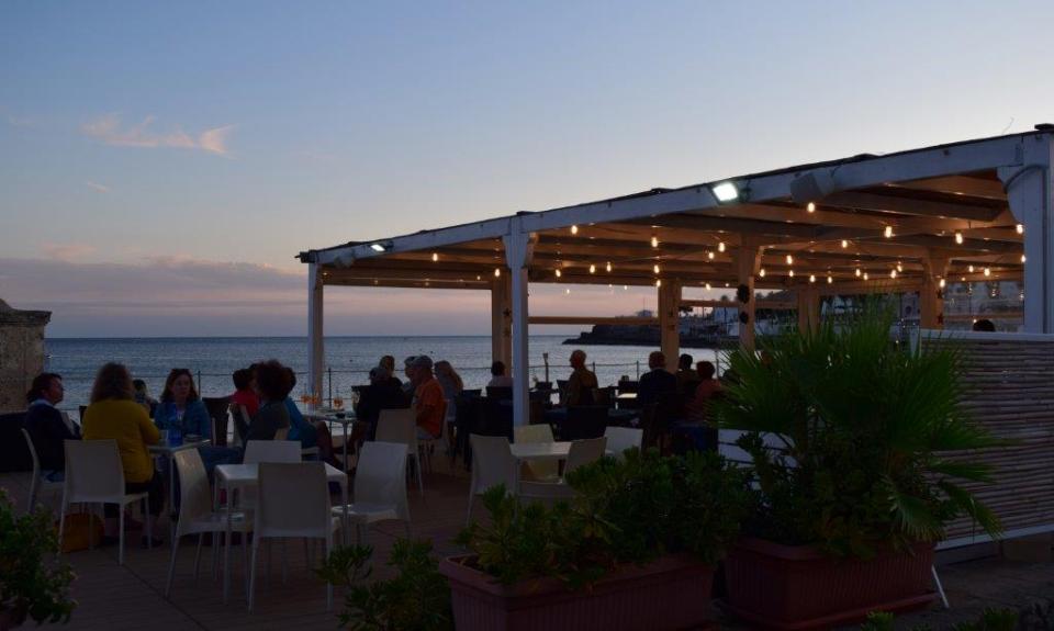 Bis spät abends genießen die Touristen die Meeresluft an einer Strandbar in Santa Maria di Leuca in Apulien.