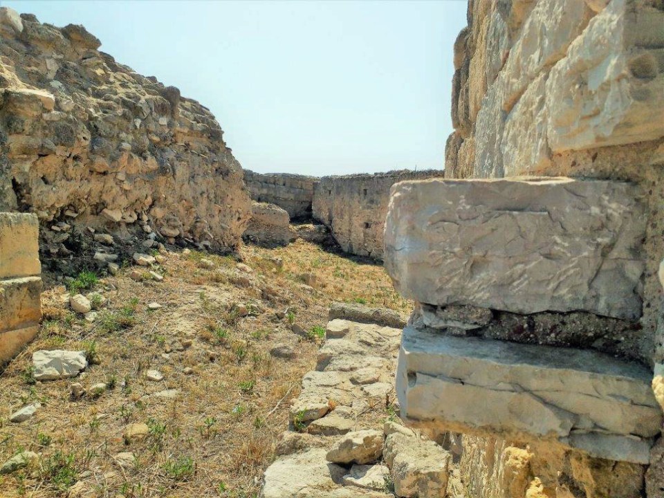 Straße zwischen verfallenden Mauern der mittelalterlichen Stadt Canae, Canne della Battaglia in Apulien.