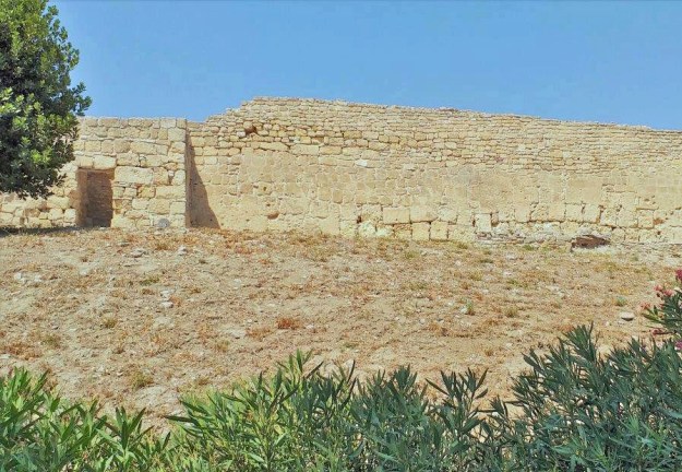 Wenn man von unten auf den Hügel mit der Ruine des Kastells von Canne della Battaglia in Apulien schaut, sieht man nur die wehrhafte Stadtmauer aus dem Mittelalter.