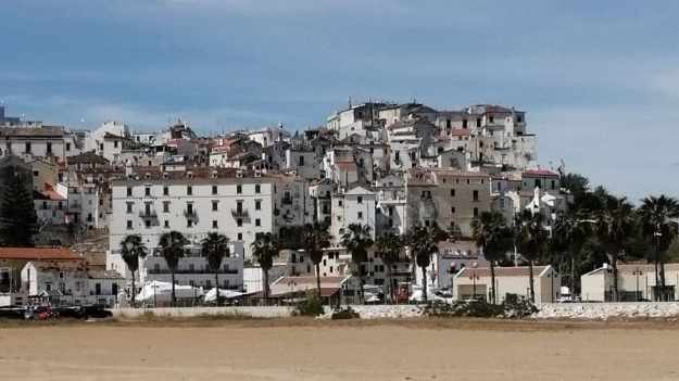 Der gelbe Sandstrand von Rodi Gargano. Dahinter erheben sich die Häuser der Stadt auf einem Hügel.