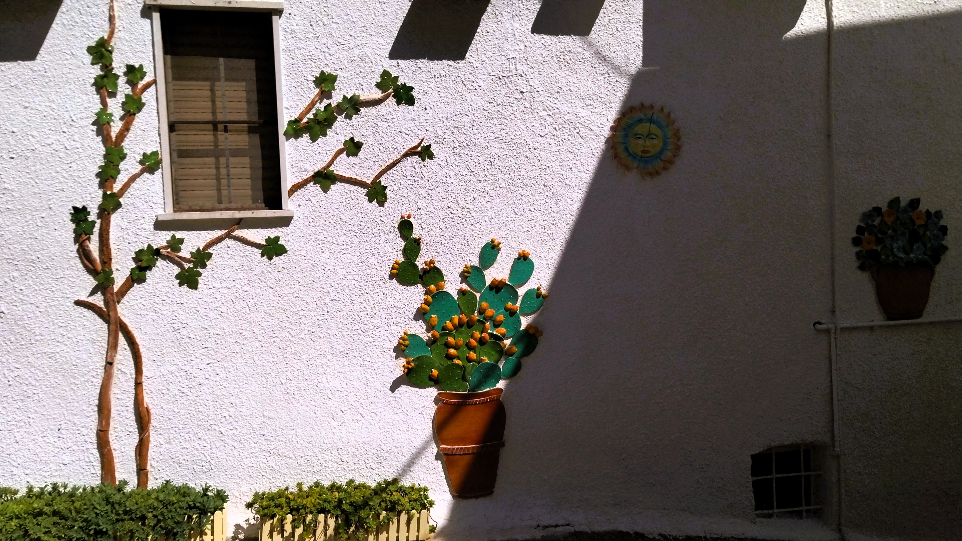 Pflanzen aus Keramik dekorieren eine Hauswand in Pisticci in der Basilikata, Süditalien.
