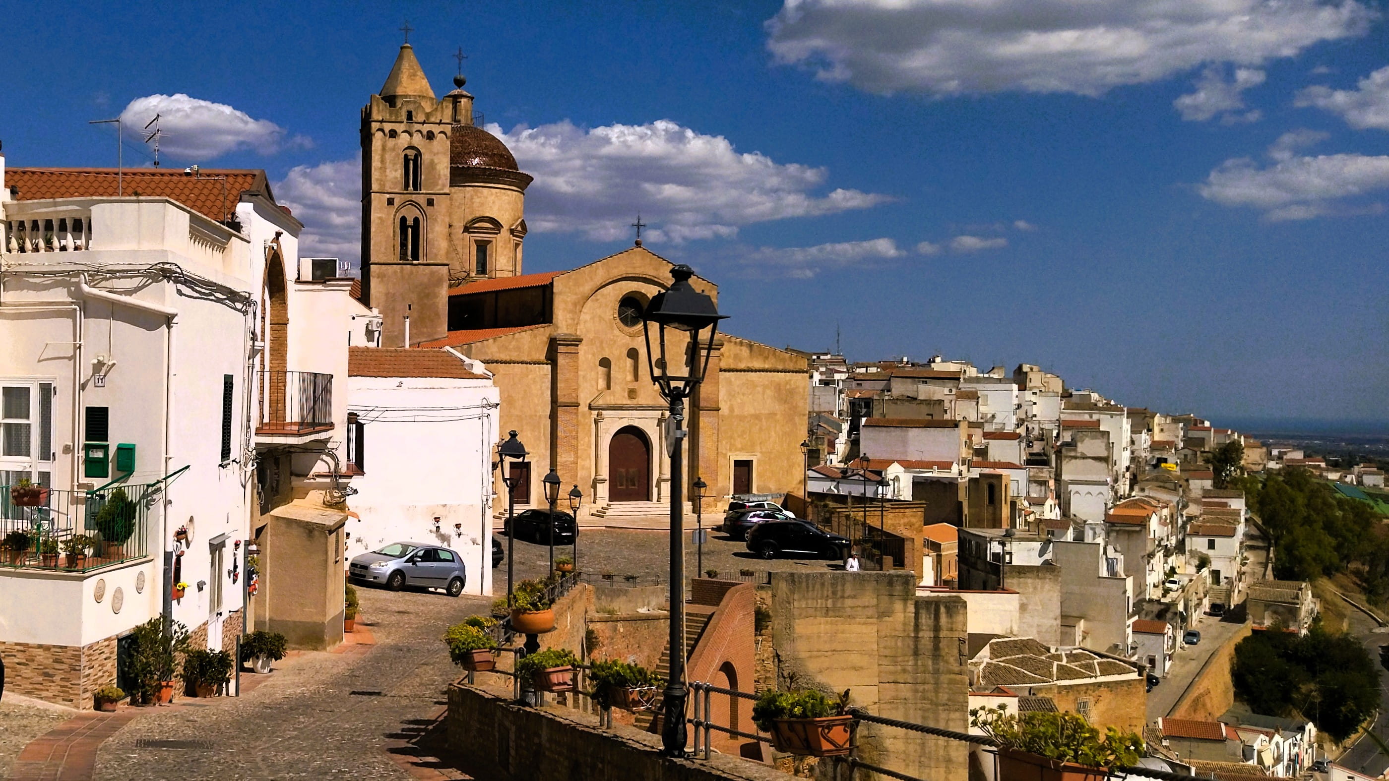 Das Zentrum von Pisticci mit dem Stadtviertel Diruppo, das aus kleinen weißen Häusern mit Spitzdächern besteht, und der Hauotkirche "Sankt Peter und Paul"