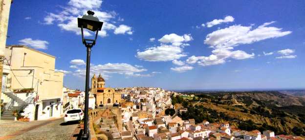 Vor dem Betrachter breitet sich das Stadtpanorama von Pisticci in der Basilikata mti den keinen weißen Häusern mit spitzen Ziegeldächern des Stadtteils Diruppo aus.