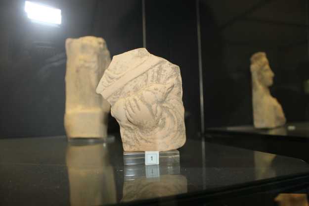 Scherbe eines Torso einer hellenistischen Statue mit Schwein in der Hand in einer Vitrine des Archäologischen Nationalmuseums Siritide in Policoro, Basilikata