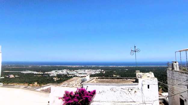 Ein weiter Blick über die Olivenhaine von der Altstadt Ostunis in Apulien aus bis hin zum Meer.