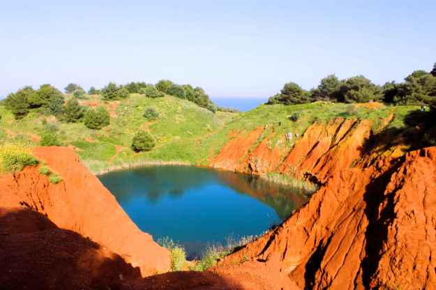 Landschaft der ehemaligen Bauxitgrube bei Otranto, Apulien, mit Farbkontrast zwischen Sand und Wasser